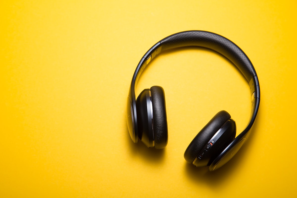 Fones de ouvido e estojo repousando em uma mesa de trabalho minimalista