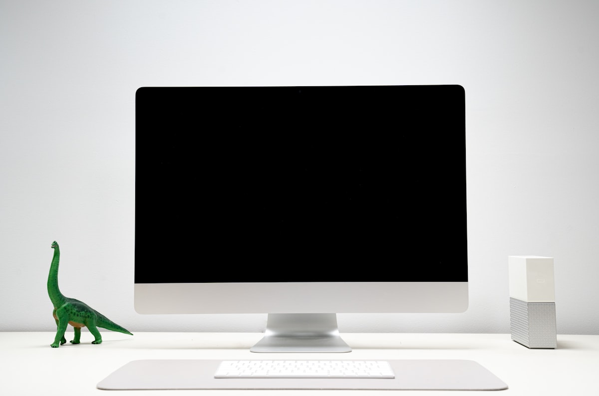 Setup de mesa moderno e minimalista com monitor, luminária de tela e organizadores