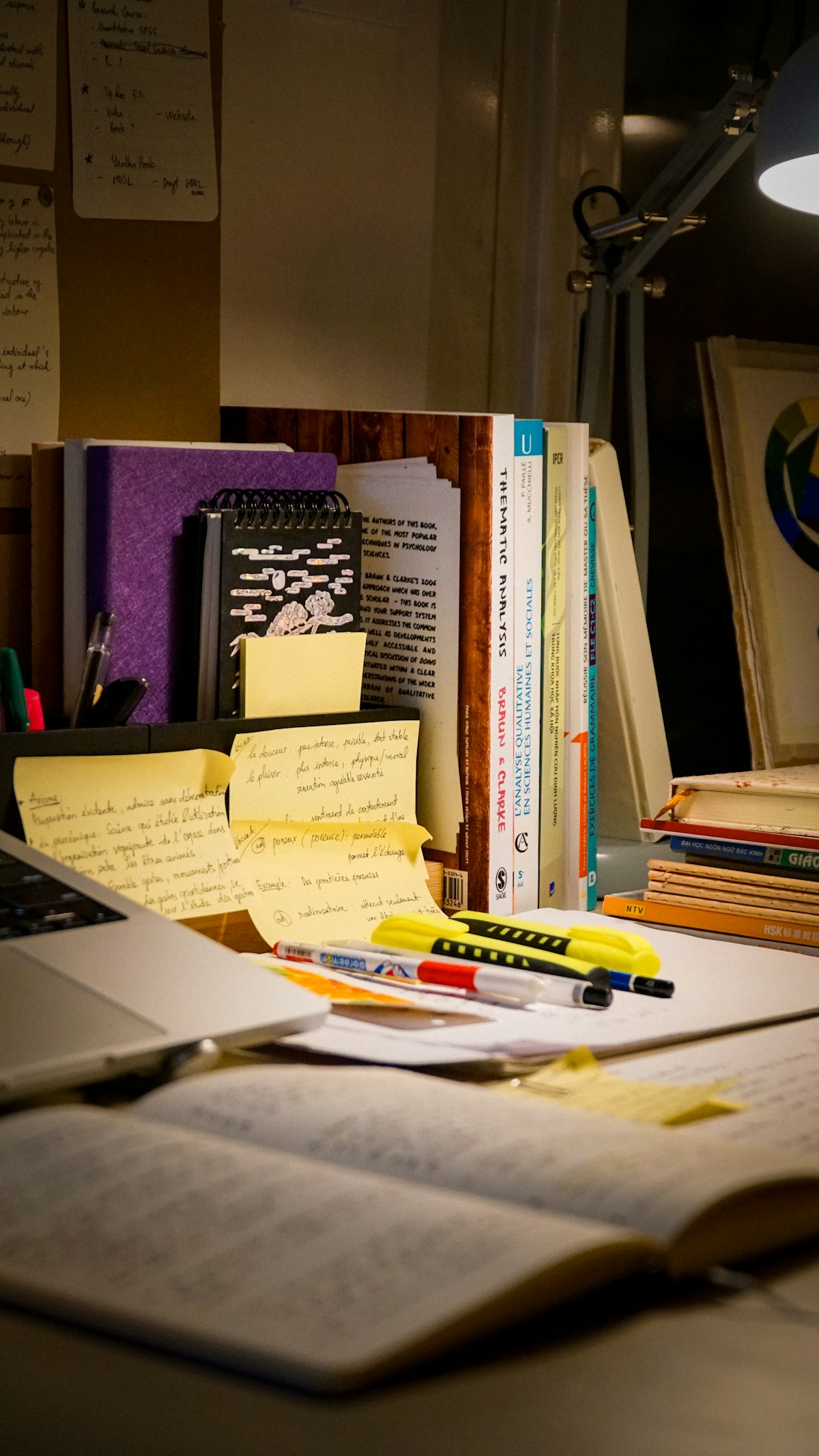 Mesa de estudos com notebook, livros e anotações
