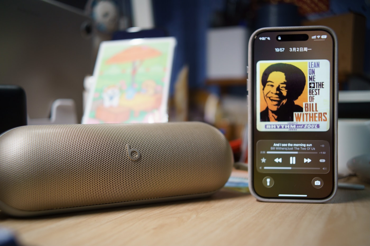 Celular tocando música ao lado de caixa de som portátil