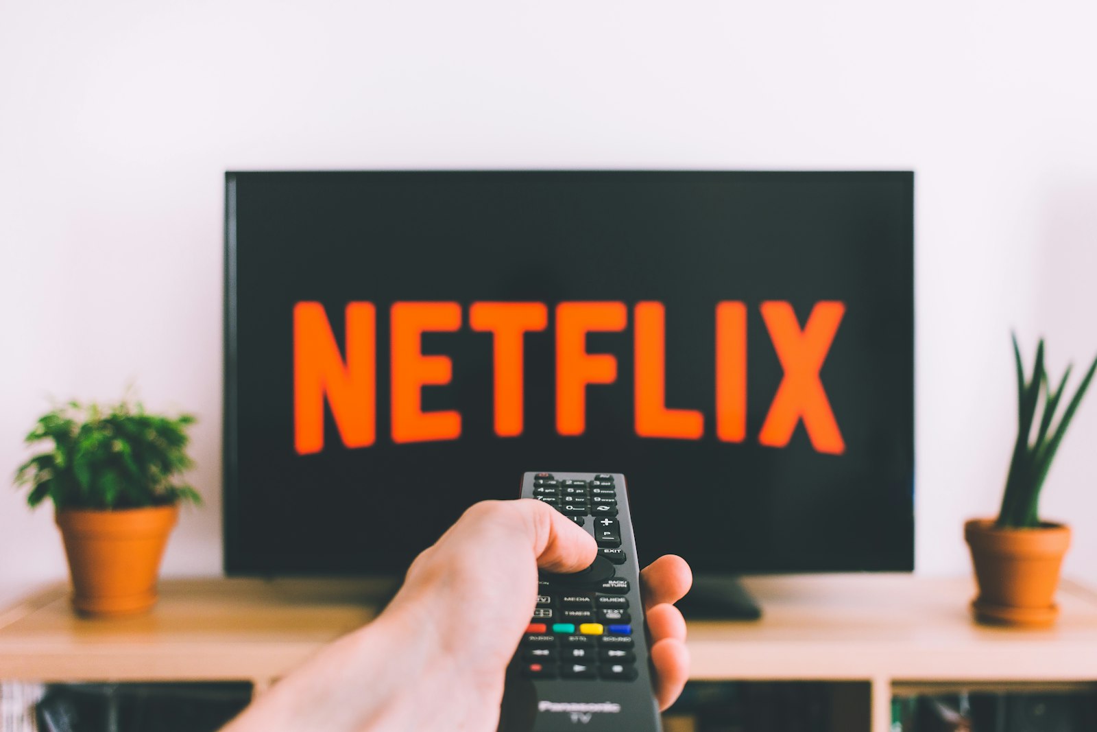 Pessoa segurando controle remoto apontado para a smart TV