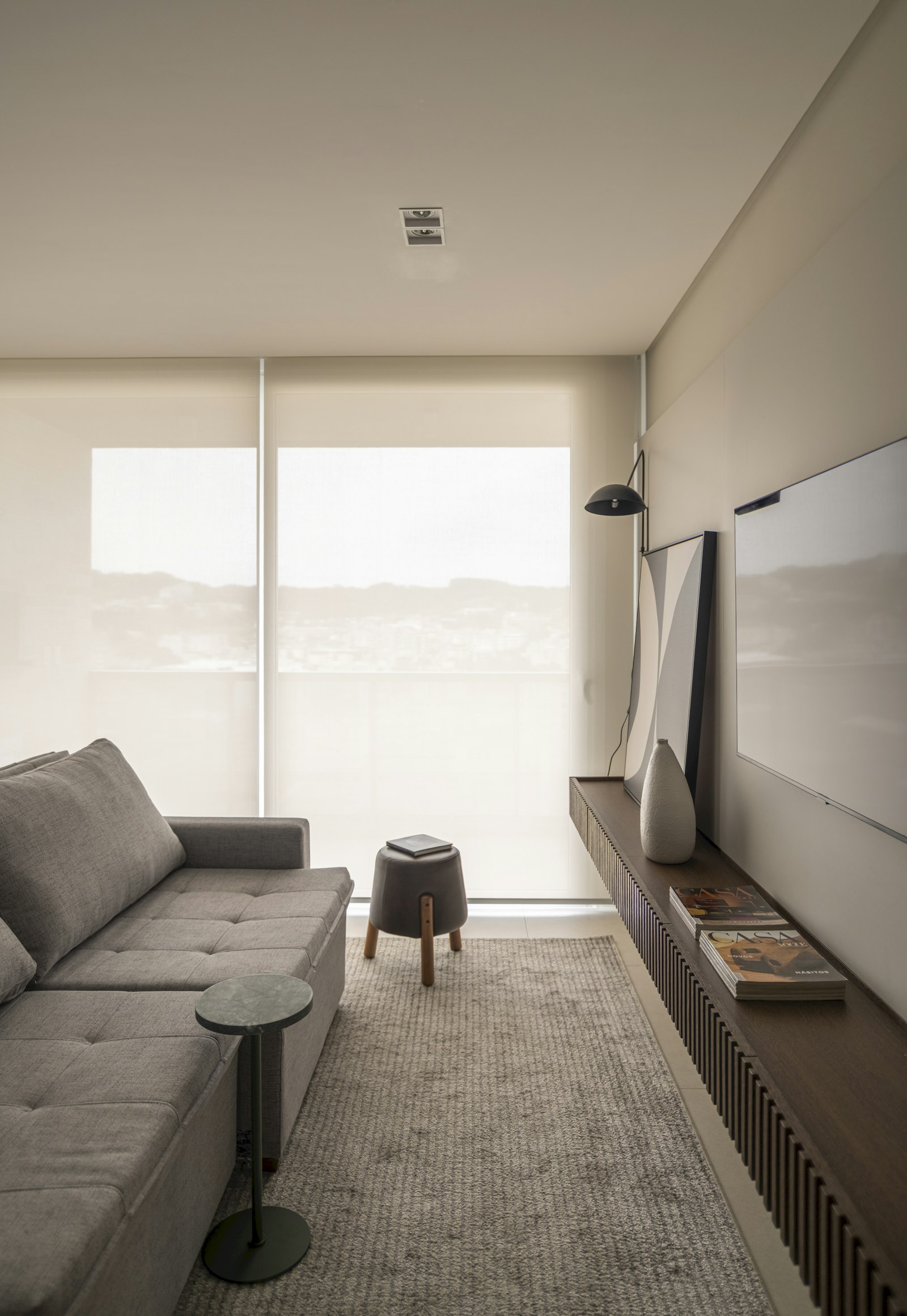Sala moderna com sofá cinza e smart TV na parede